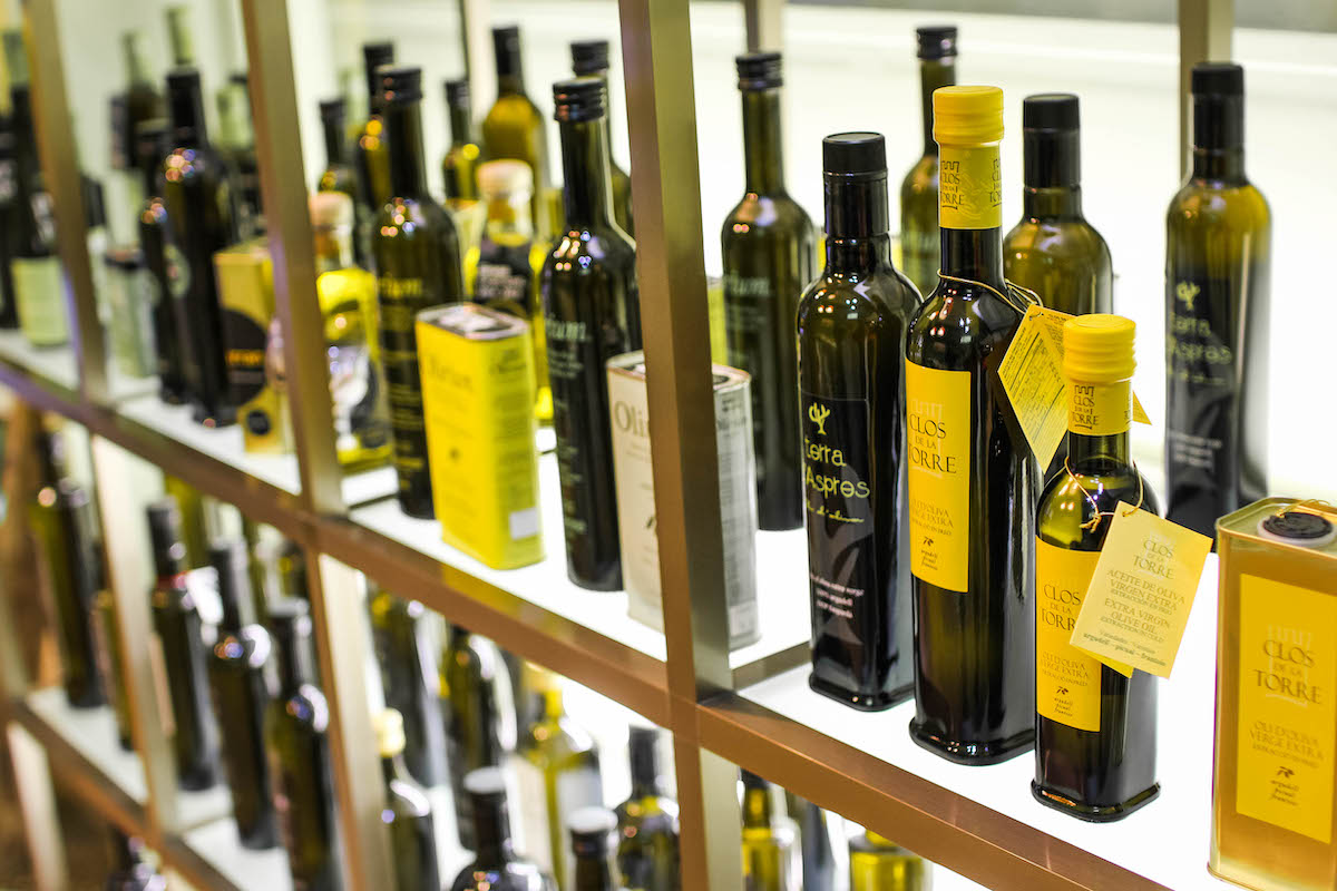 Bottles of olive oil on display at a shop with seals from the Denomination of Origin in Spain.