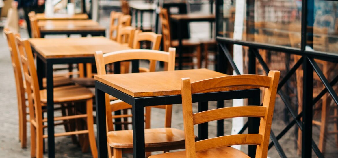 Wooden tables and chairs at a sidewalk cafe in Italy