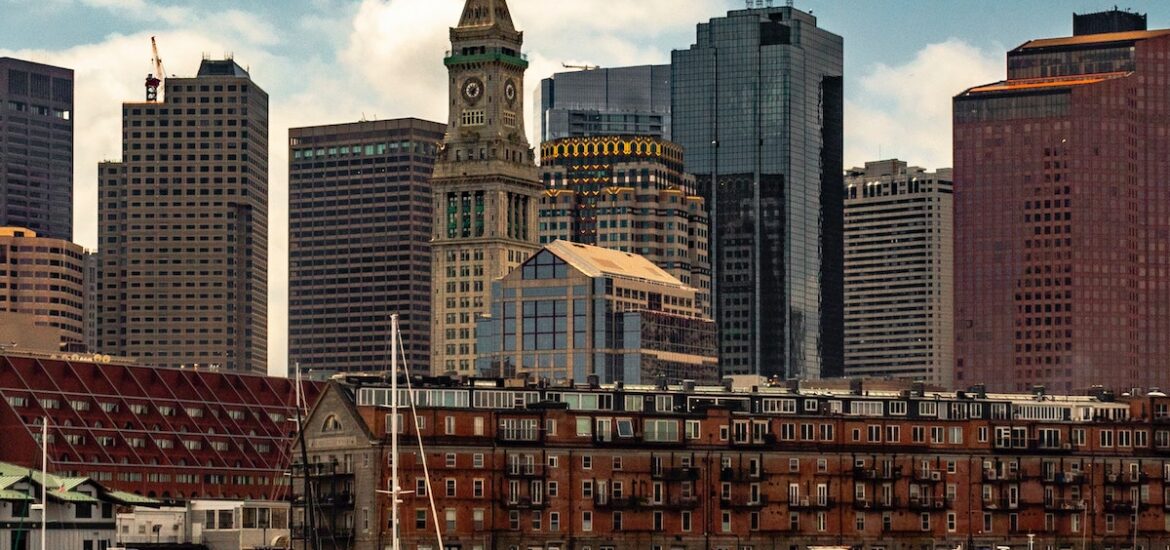 Boats floating in the water of Boston Harbor with the skyline in the background