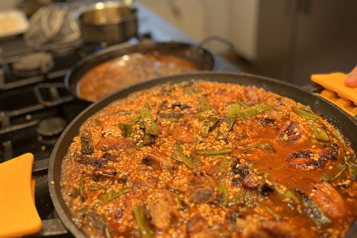 a large plate of paella being cooked on a stove