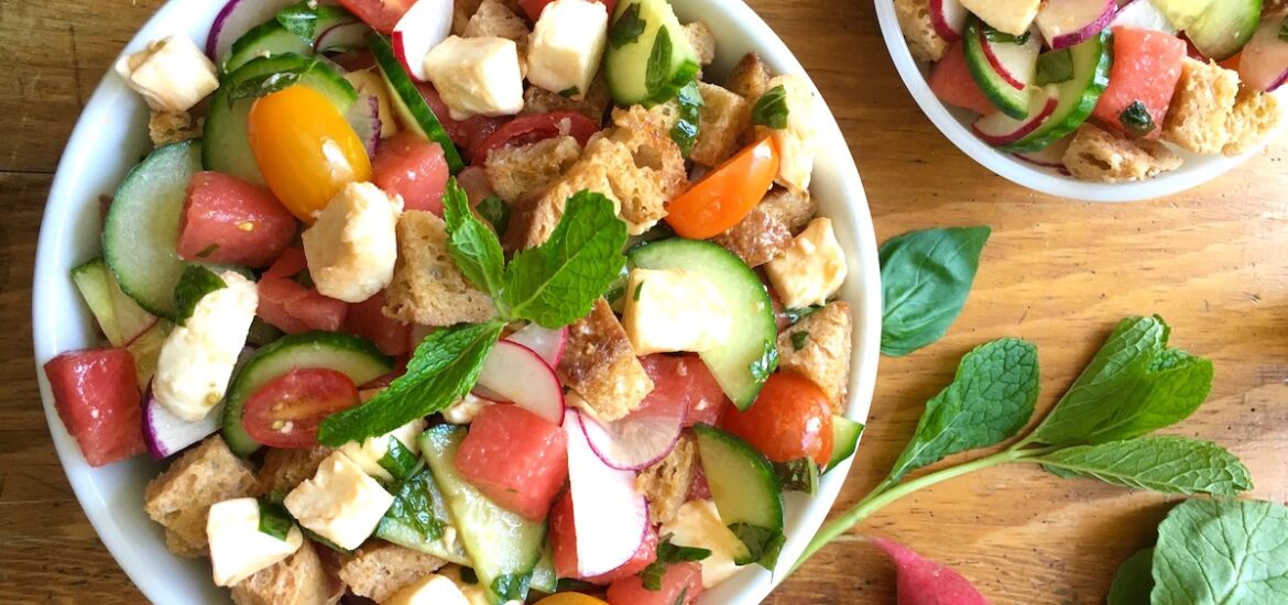 Overhead shot of one large and one small bowl of Tuscan bread salad with vegetables