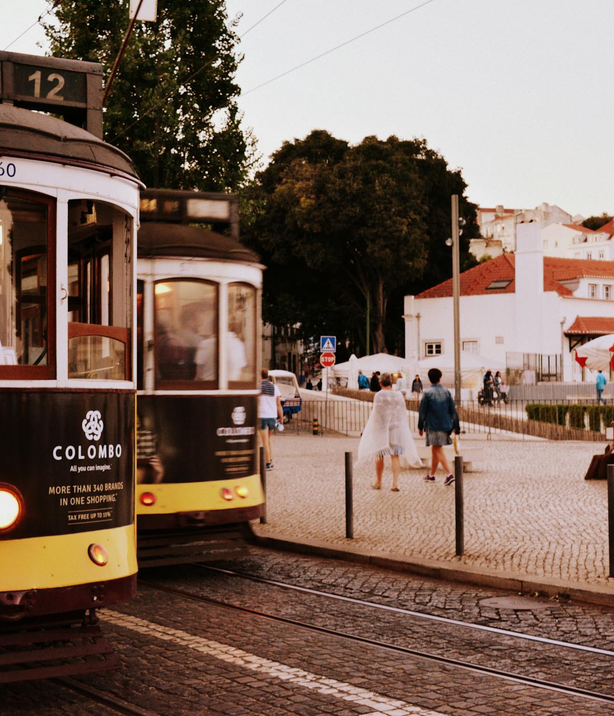 Two trolleys going down the streets in Portugal. 