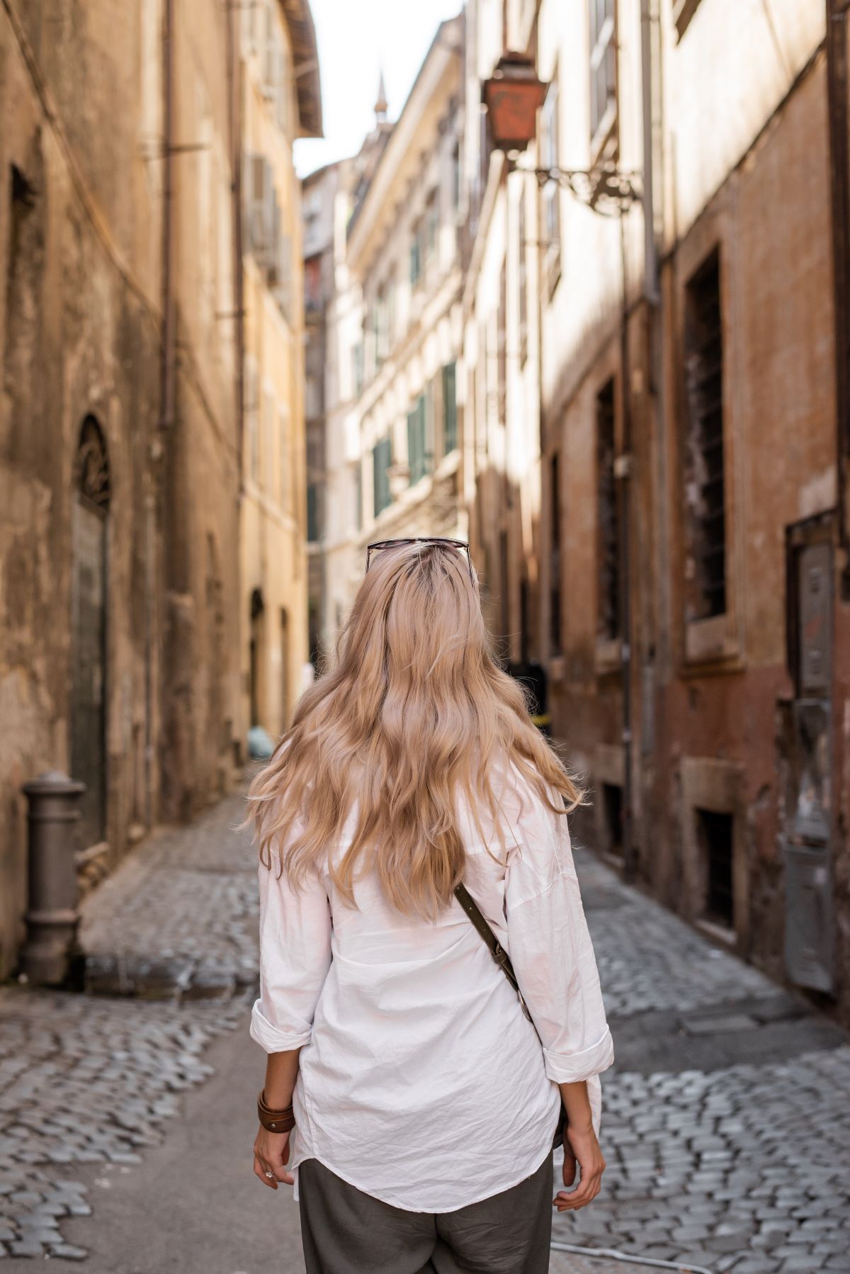 female standing on narrow street of old city