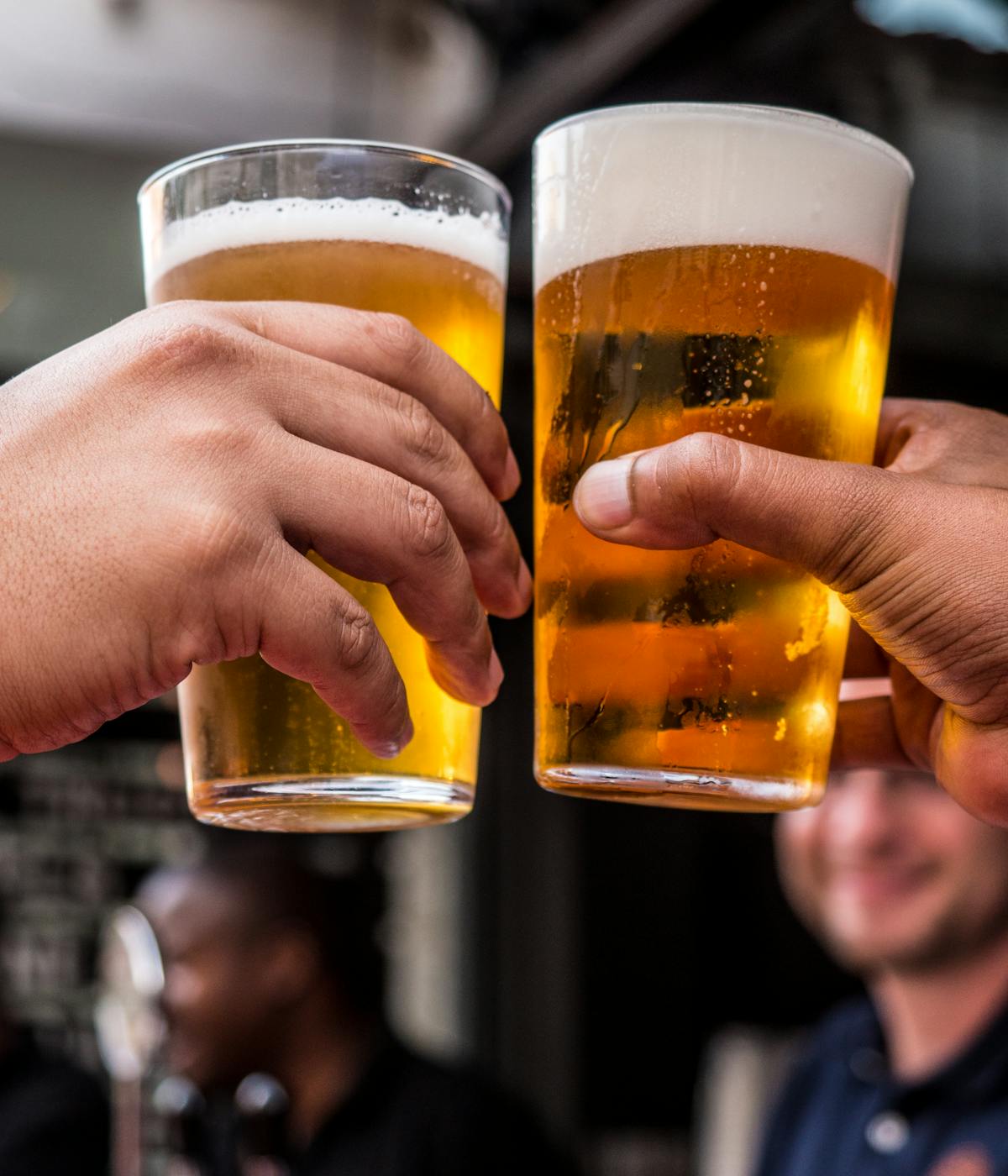 Two people cheering at a beer garden in New York City, one of many hidden gems in New York. 