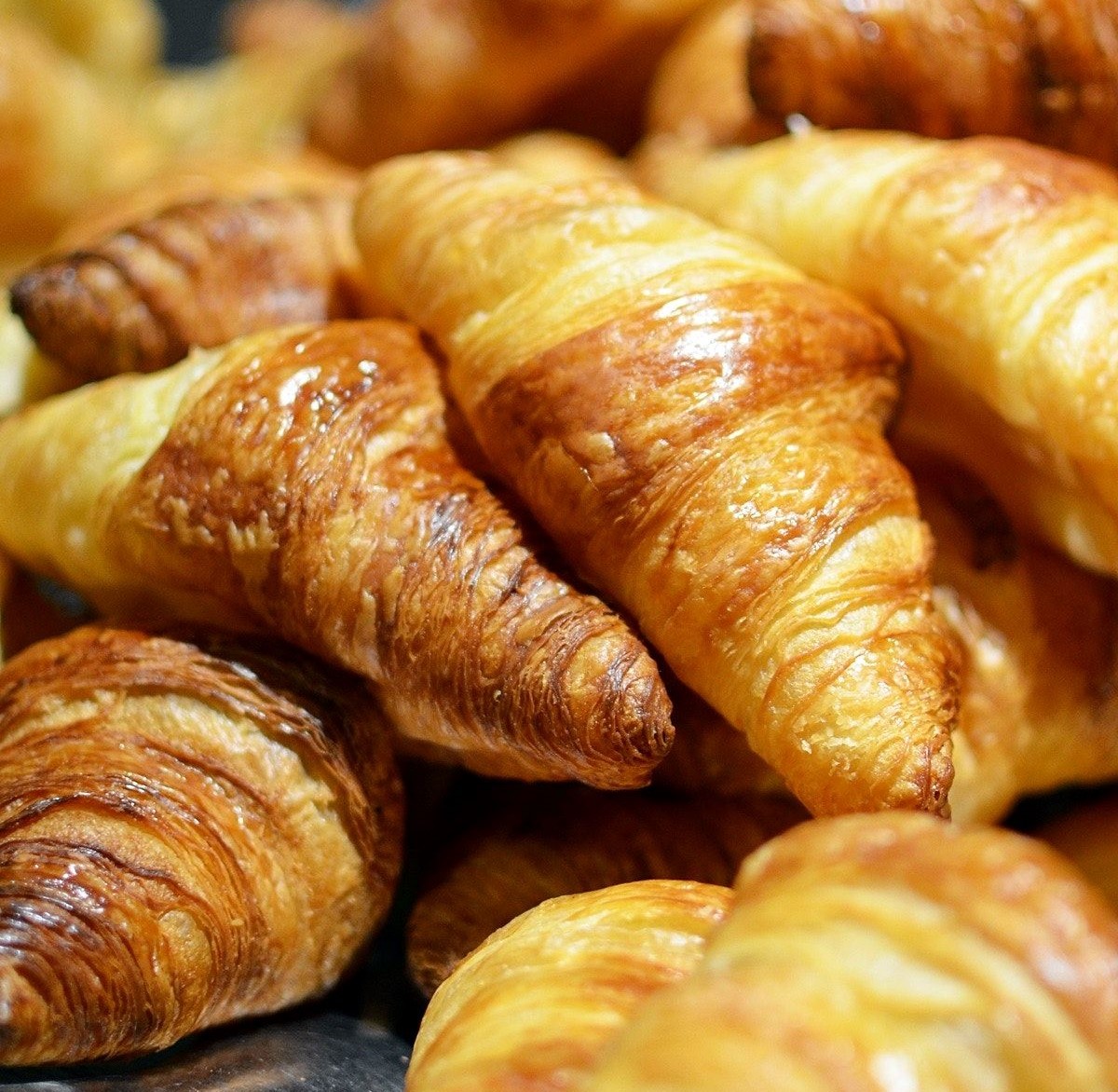 Rows of croissants freshly baked at one of the best bakeries in Paris. 