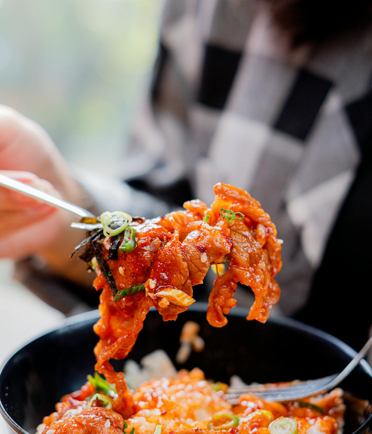 A woman eating Chinese-Peruvian fusion fried rice. 