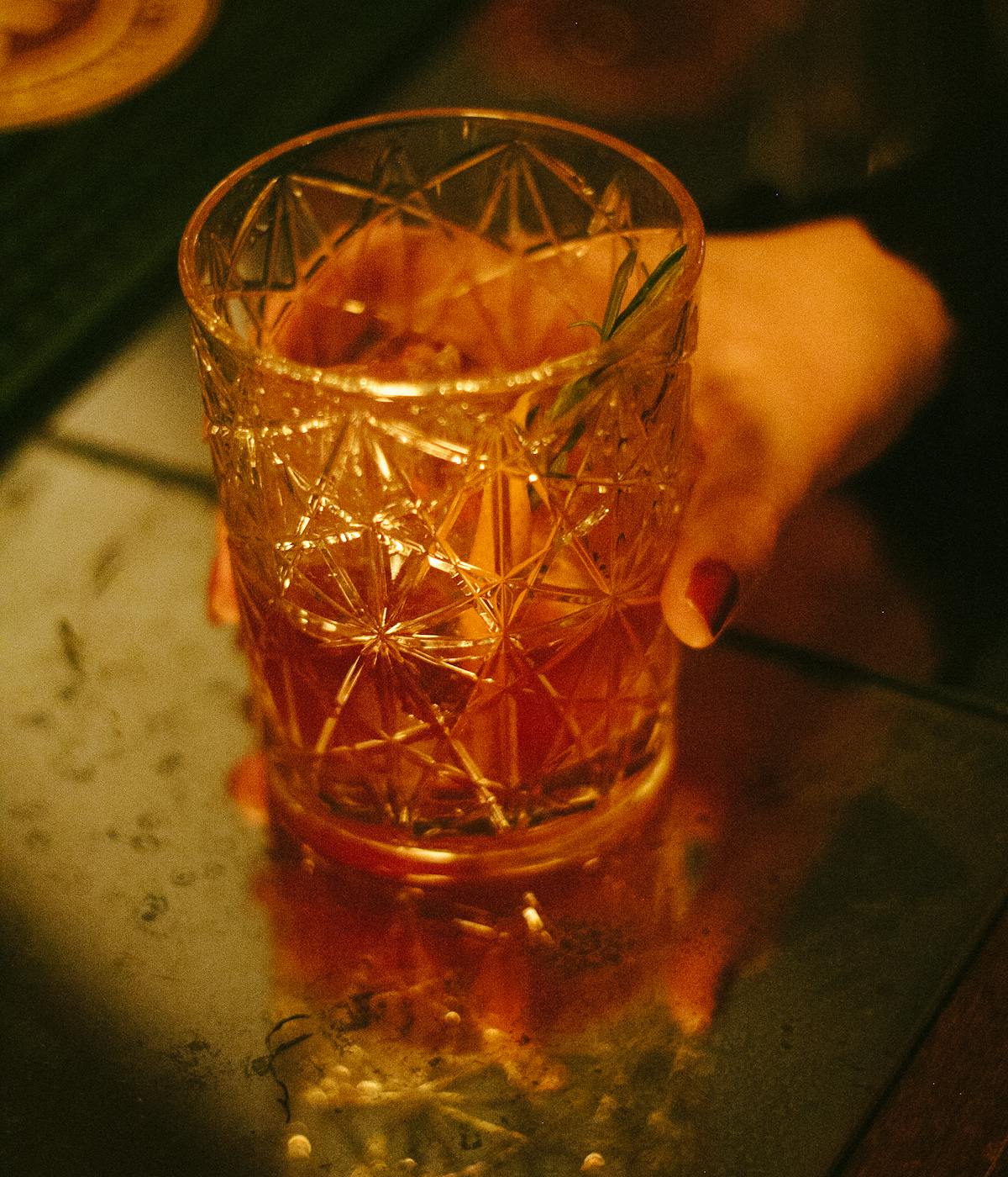 A person holding a signature drink from a speakeasy. 