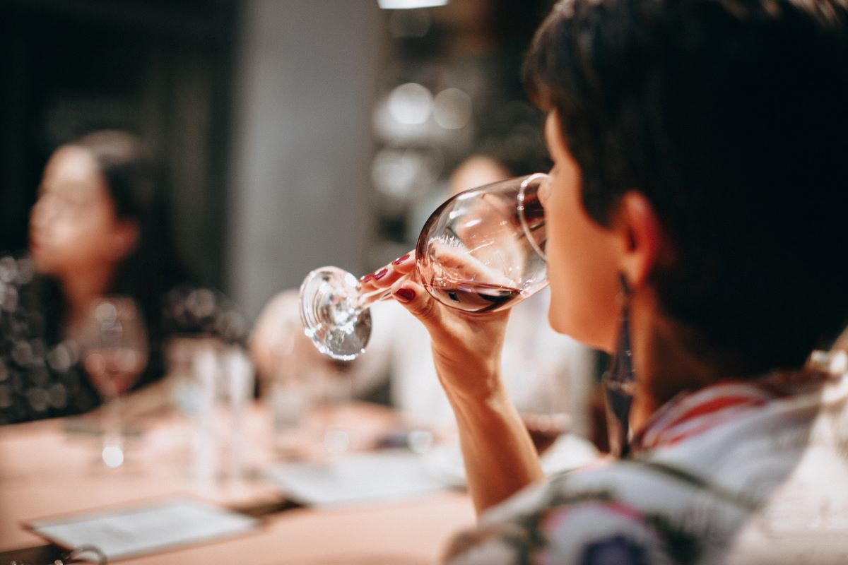 woman taking sip of red wine