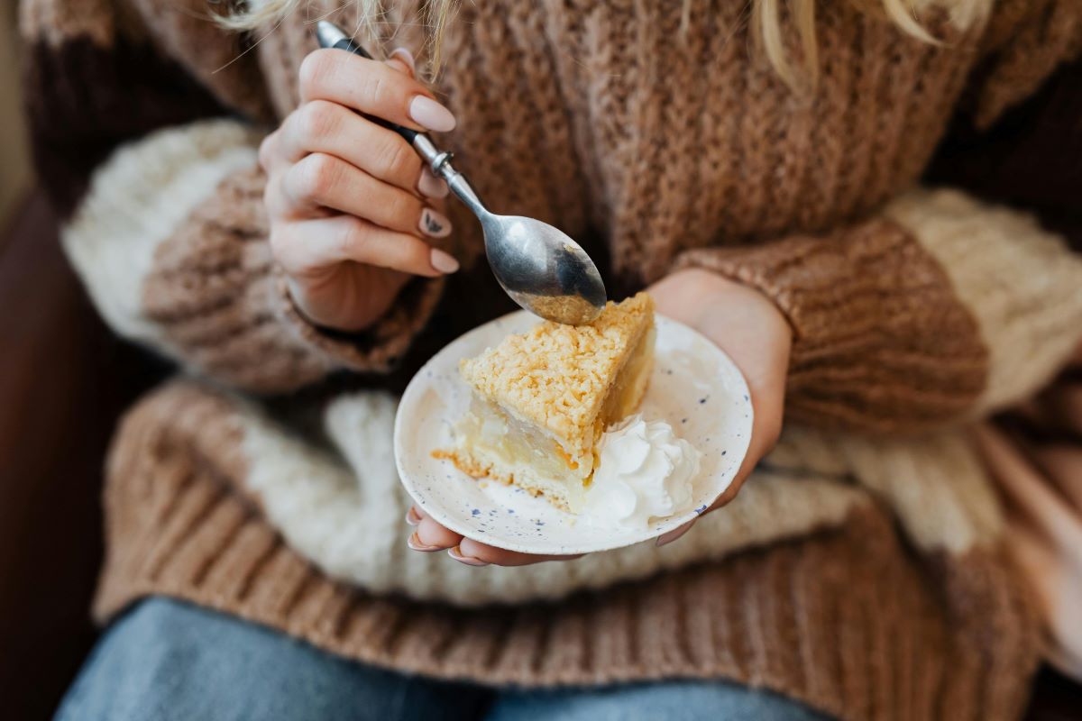 A woman taking a spoonful of apple pie in Sintra. 