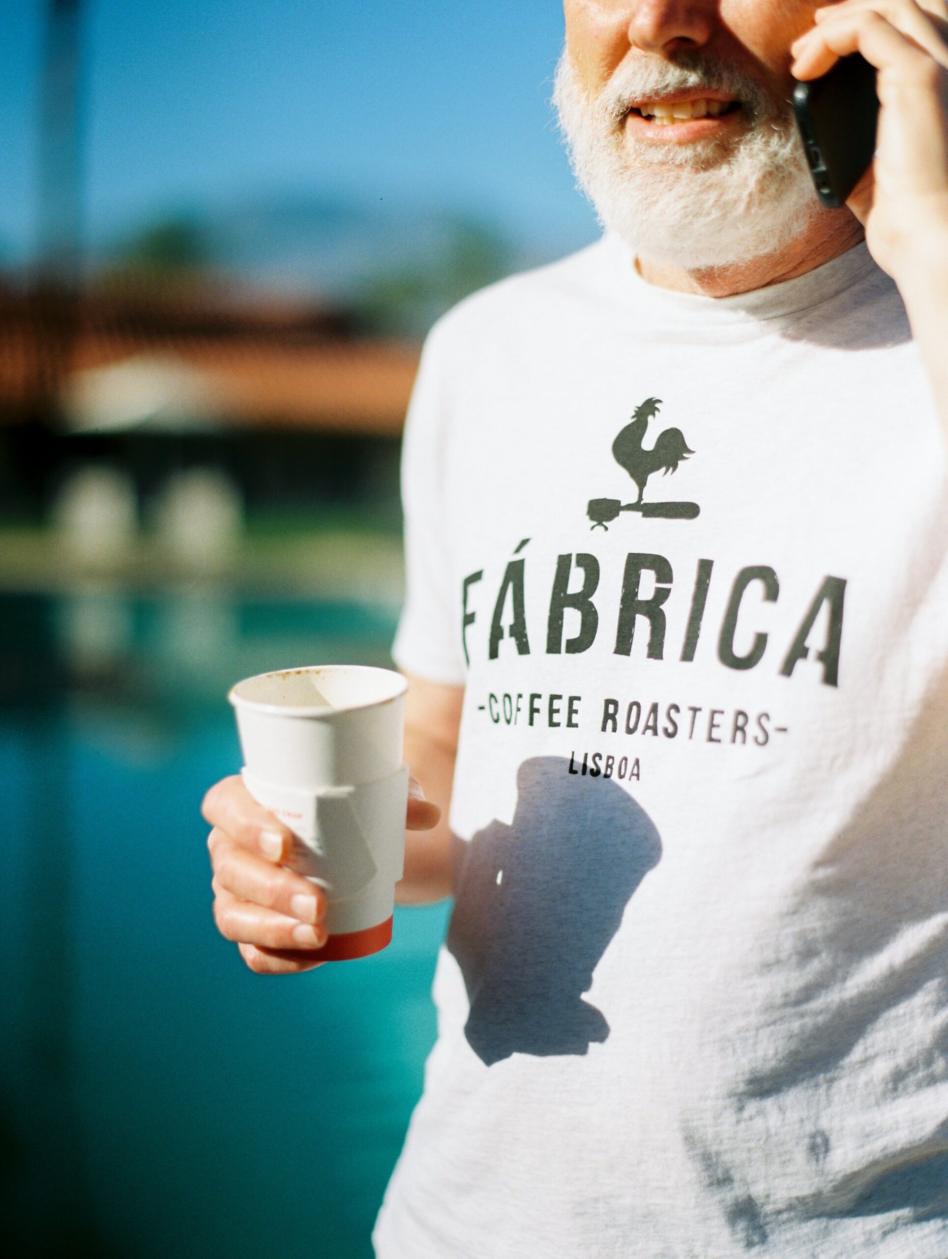 Grey-haired with beard holding coffee