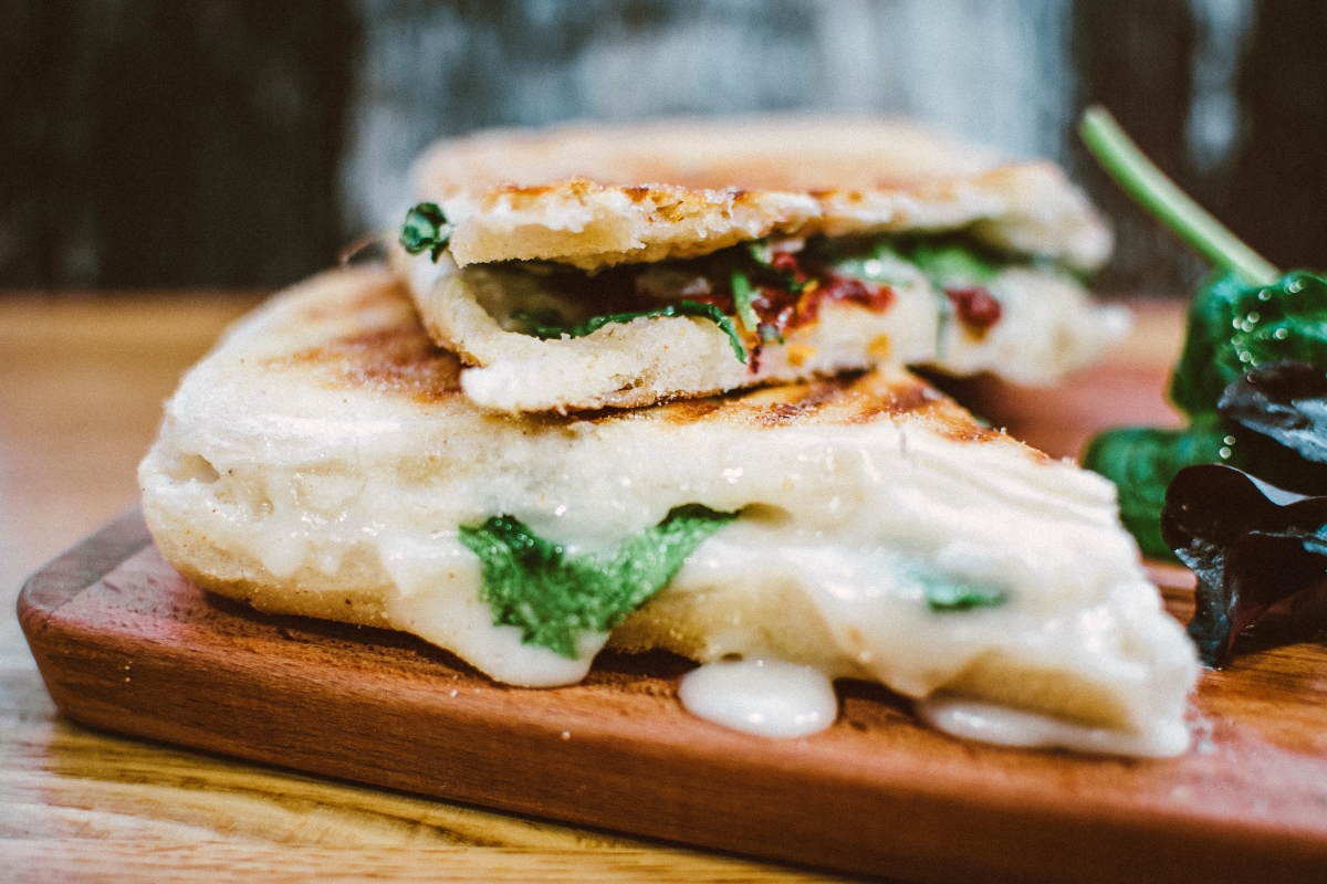 grilled panini sandwich with melted cheese and greens 