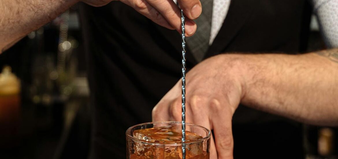 A bartender at a speakeasy making a special cocktail.