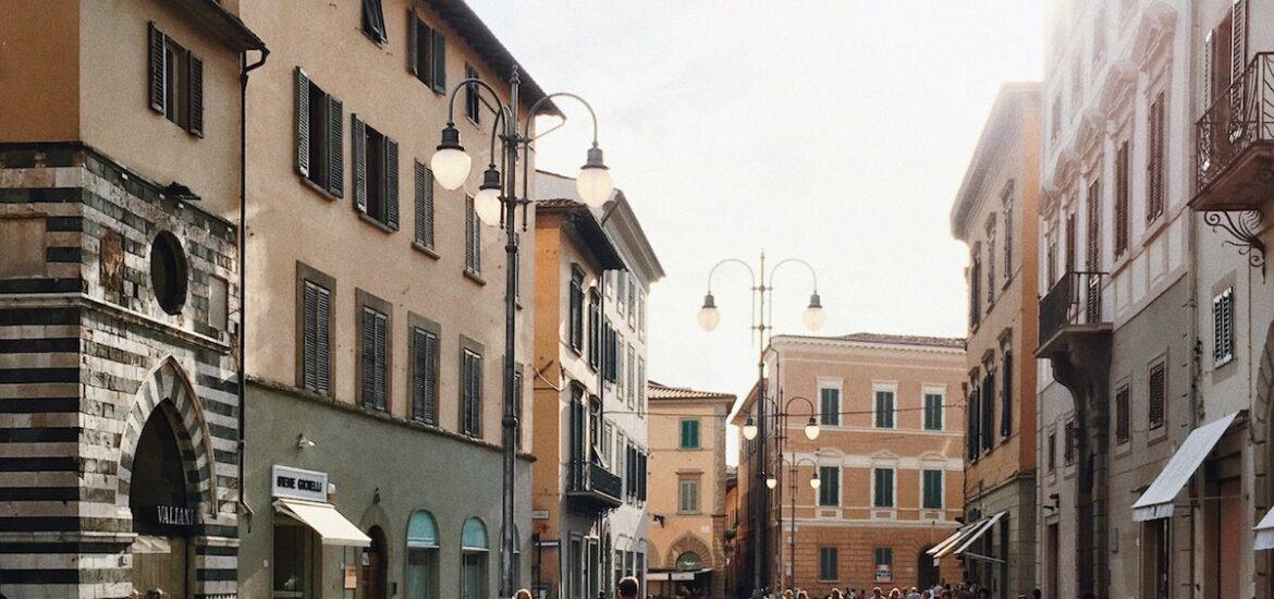 Children riding bikes in a wide pedestrian street in Italy on a sunny day