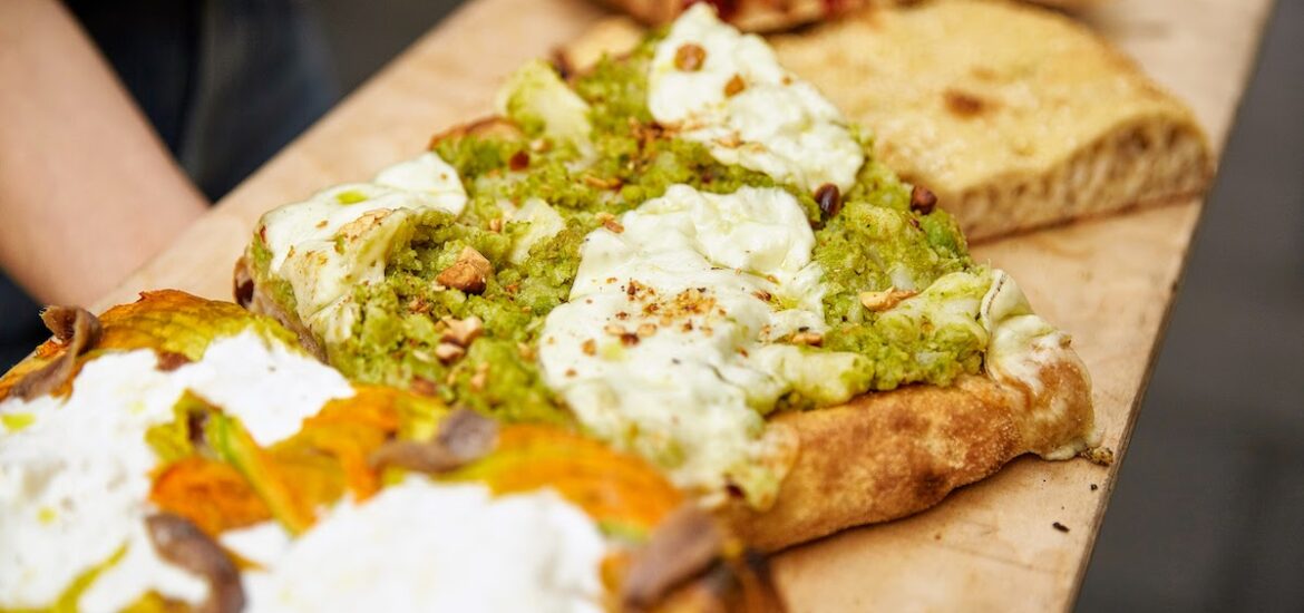 Several pieces of pizza by the slice with various toppings on a wooden board