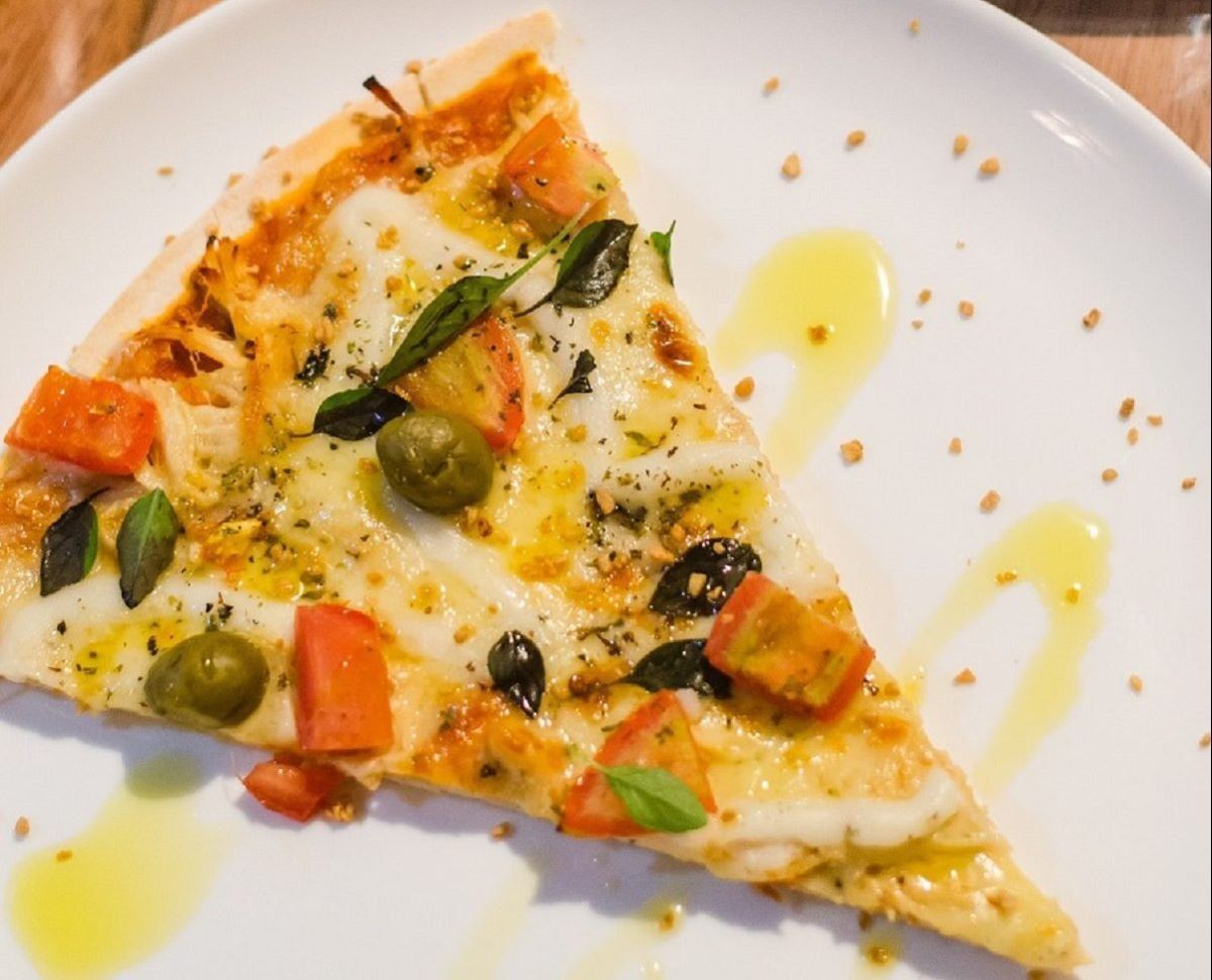 slice of pizza with veggies and honey