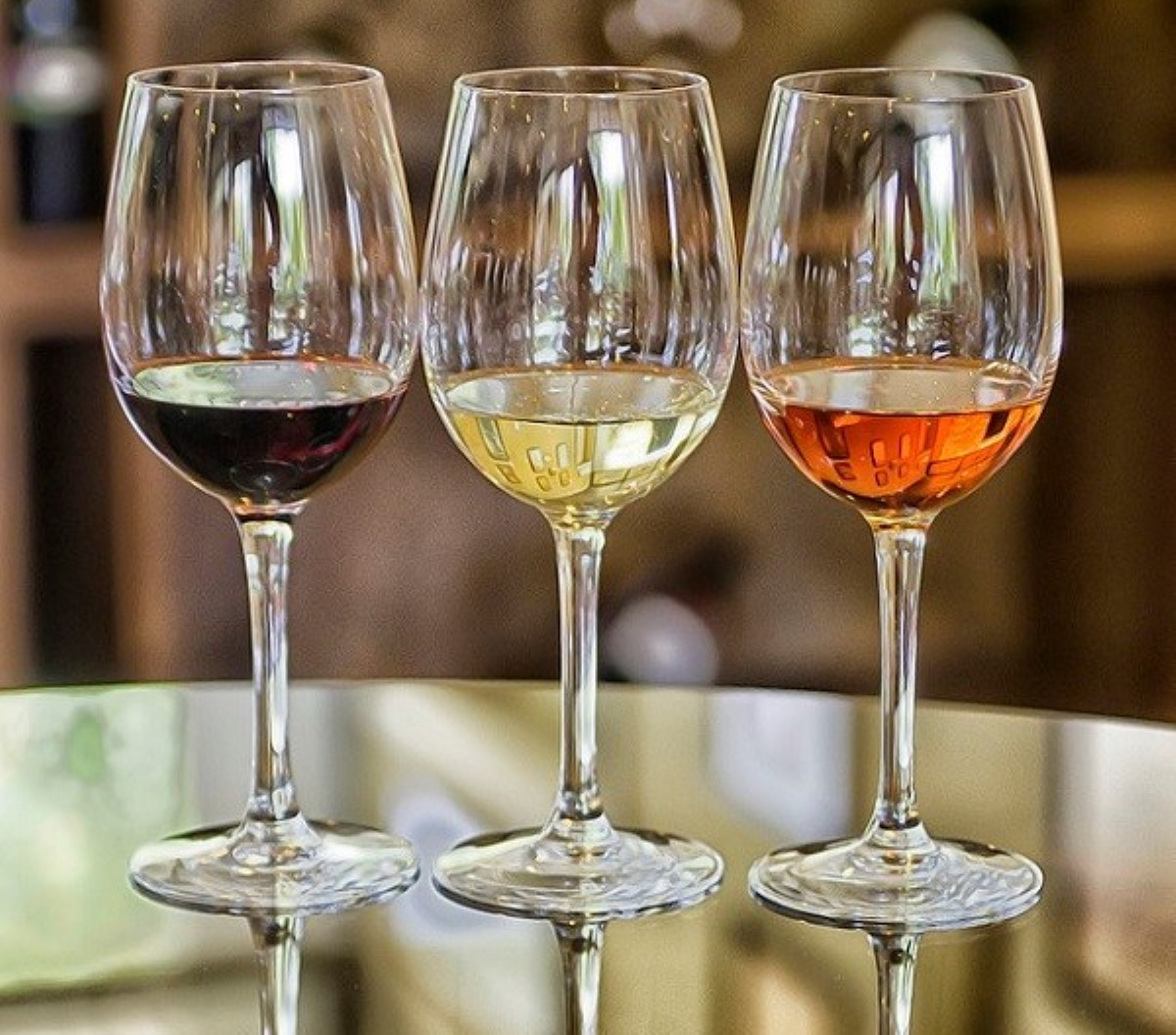 three glasses with three different types of colored liquid