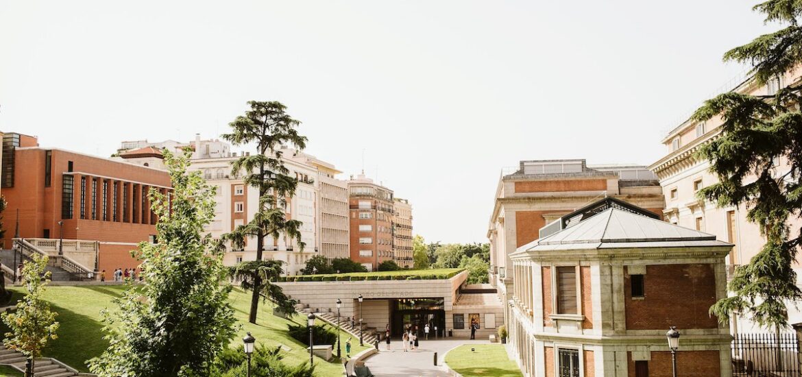 Brick and concrete buildings surrounded by trees and grass.