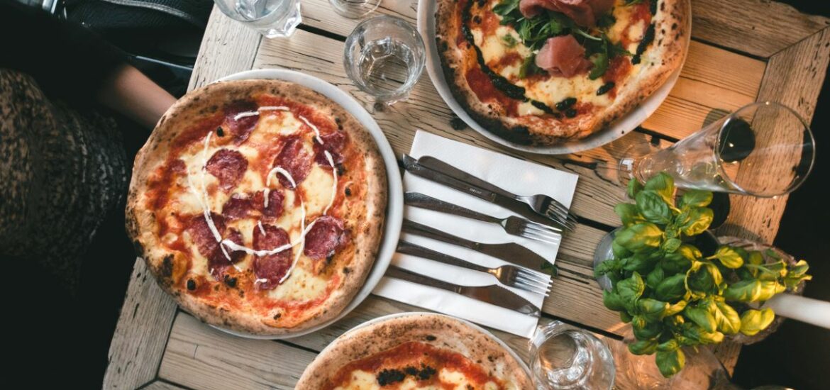 pizzas on wooden table next to beer