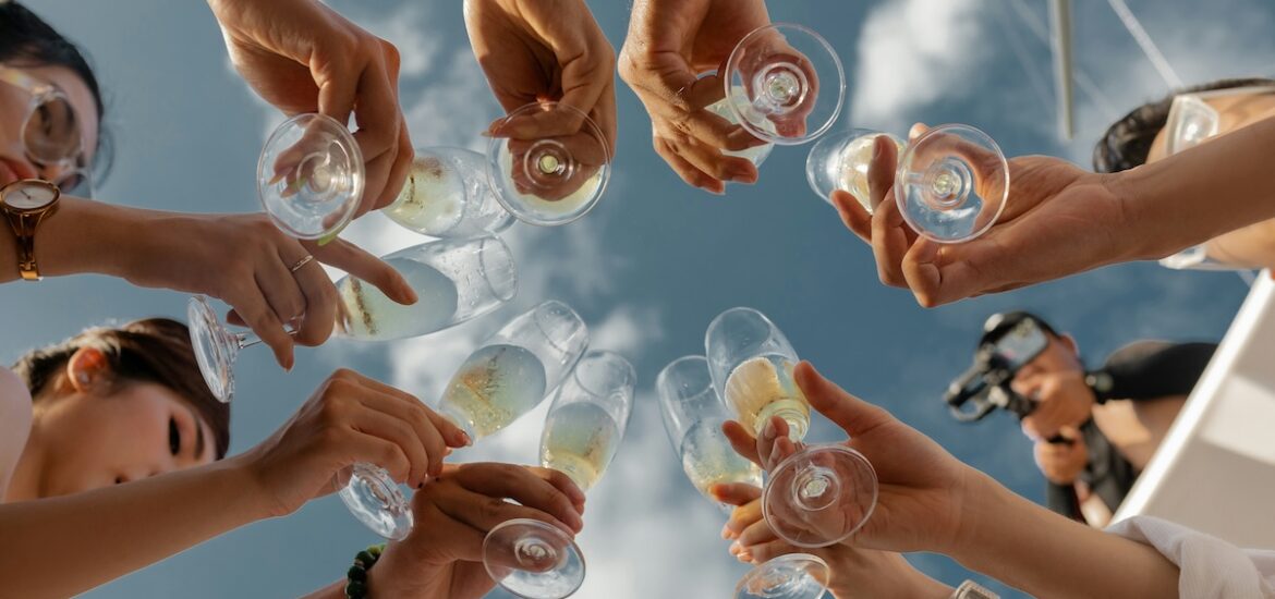 girls cheering glasses together on a sunny day