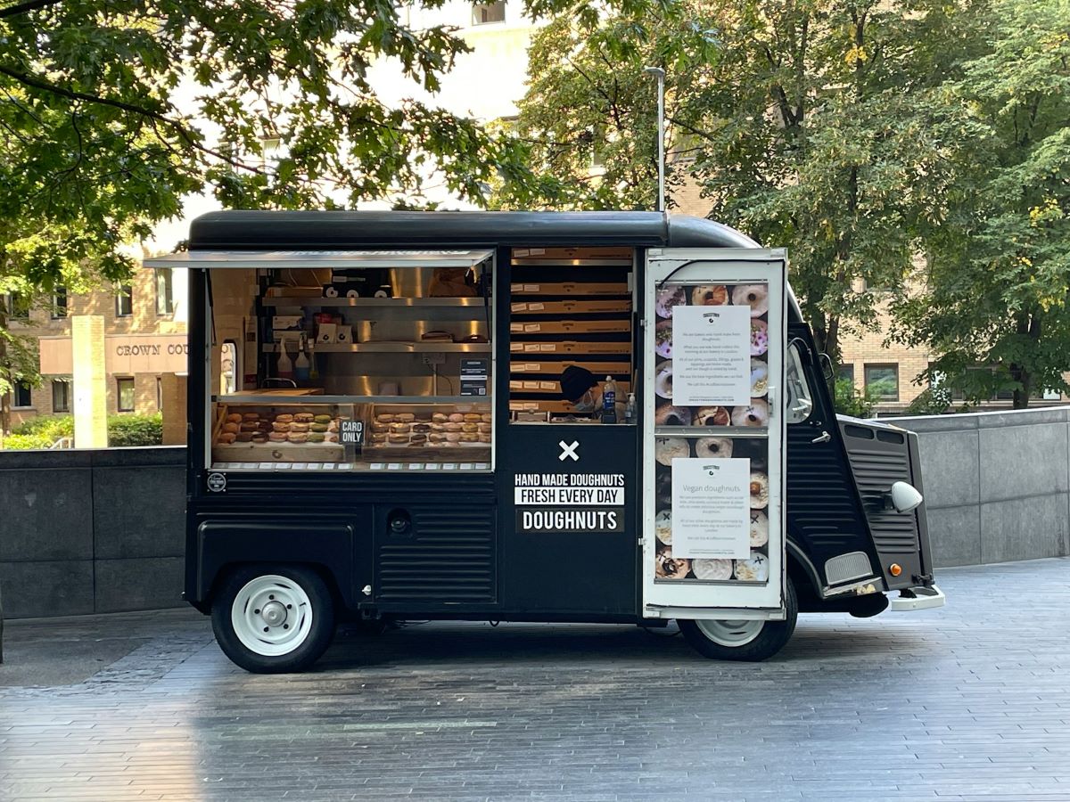 A Crosstown doughnut truck parked at a square in London. 