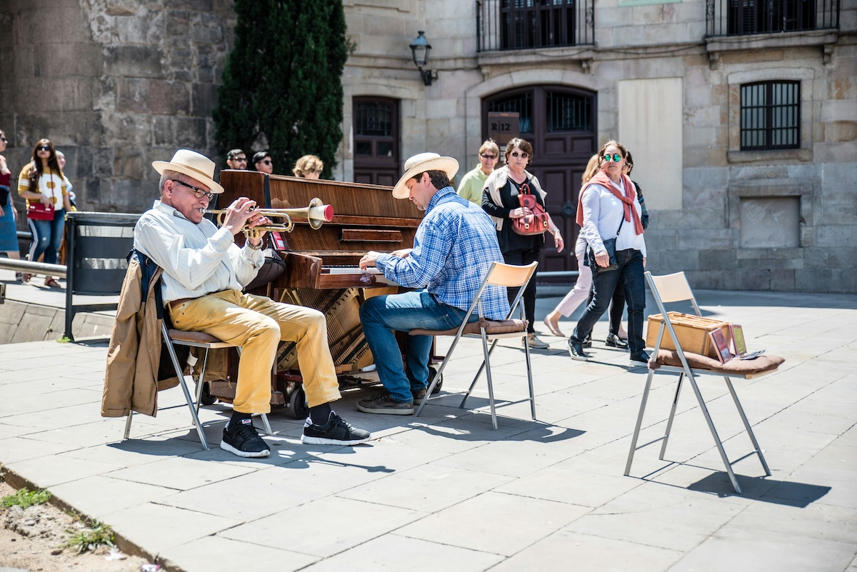 people watching street performers playing music on the streets of barcelona