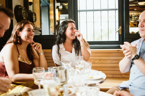 Group of people eating at a restaurant and laughing