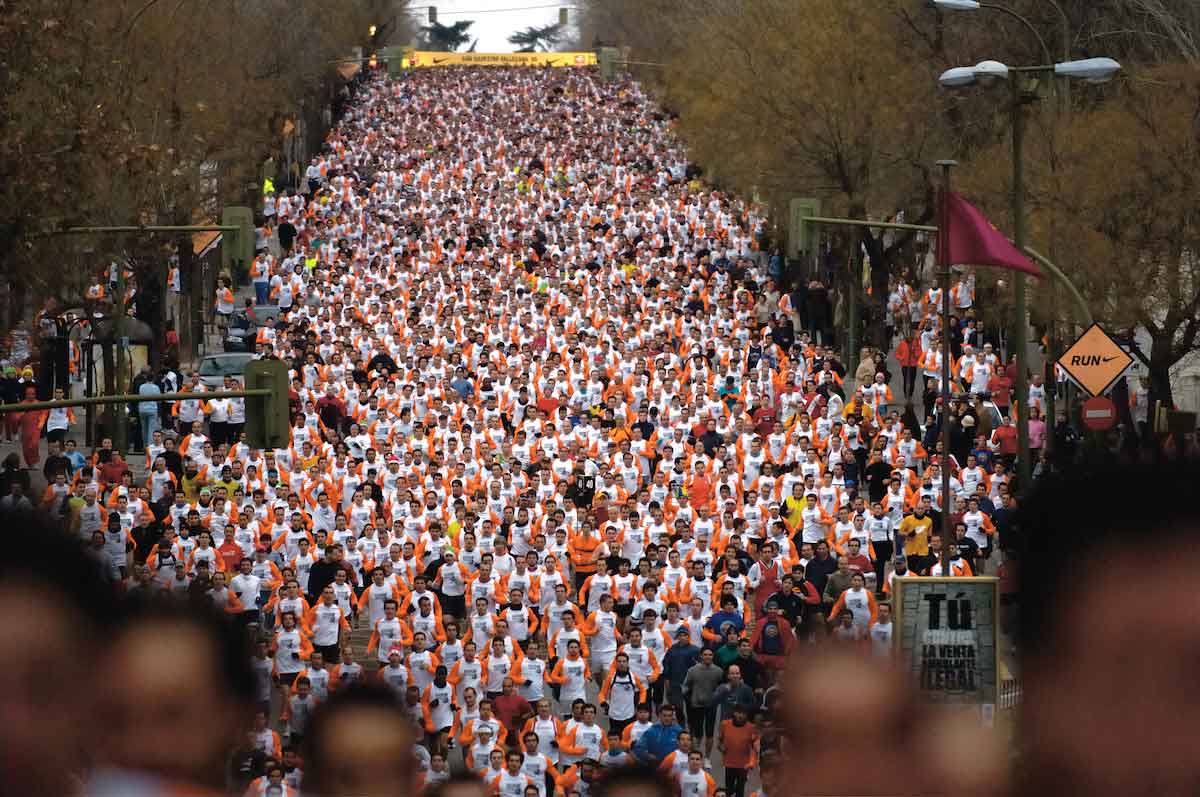 Hundreds of people running a race through city streets.