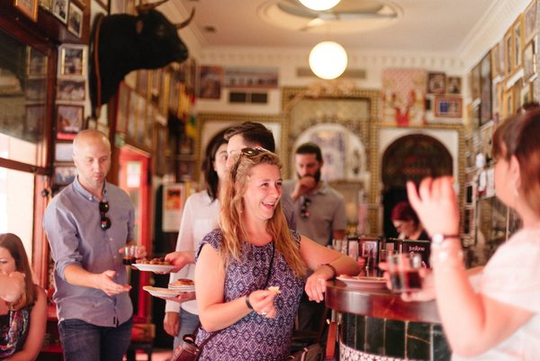 People grabbing drinks at a Seville tapas bar