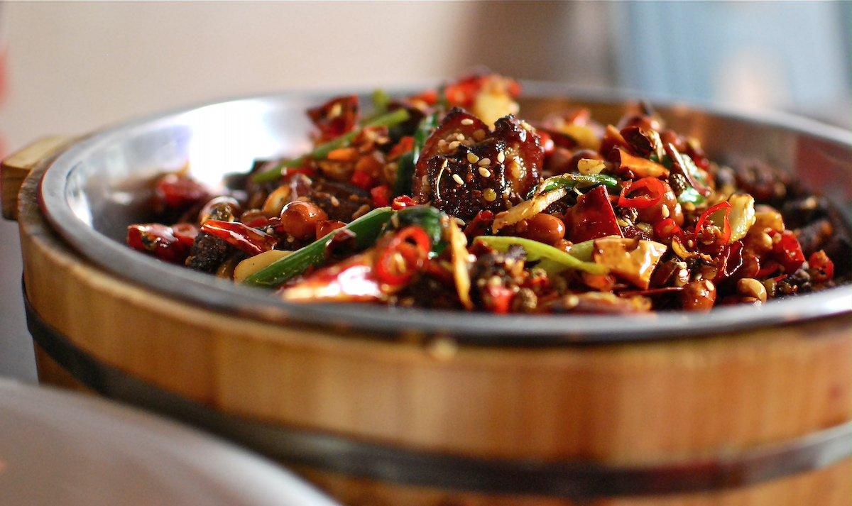 Dish of fried chicken with peanuts and red chili peppers.