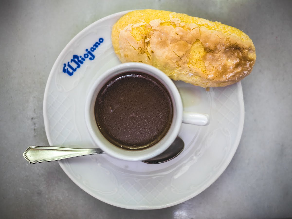 Overhead shot of a mug of thick hot chocolate with a ladyfinger cookie.