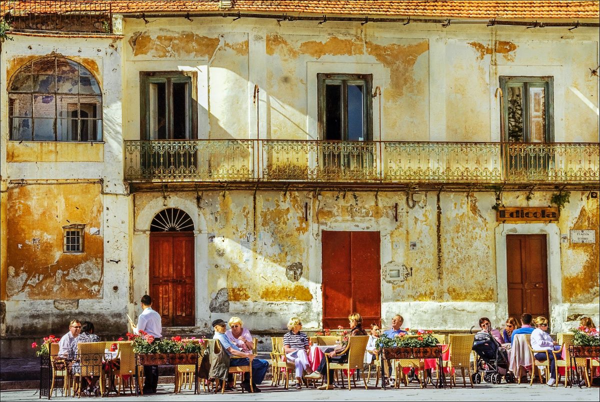 people sitting outdoors enjoying food in Naples.