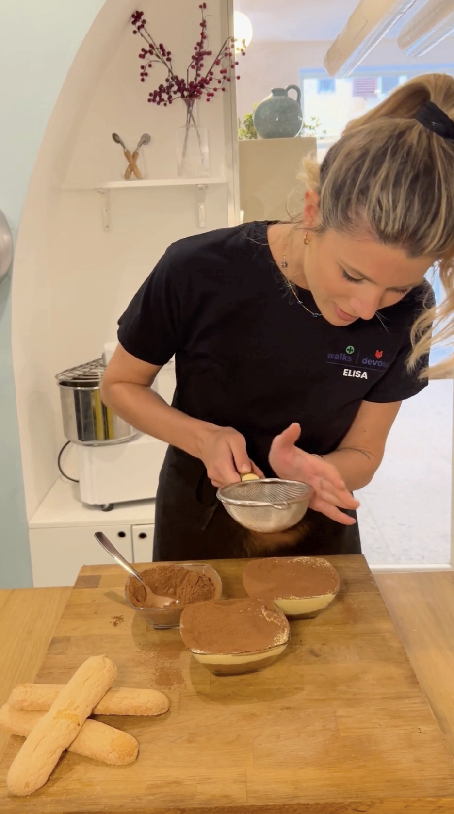 dusting the tops of bowls of tiramisu