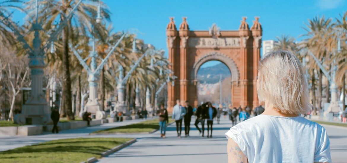 A woman walking around Barcelona visiting for the first time.