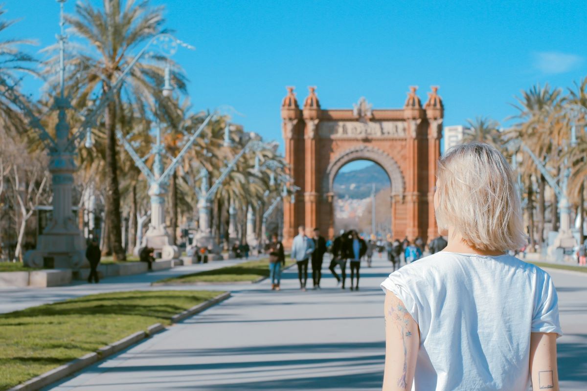 A woman walking around Barcelona visiting for the first time.