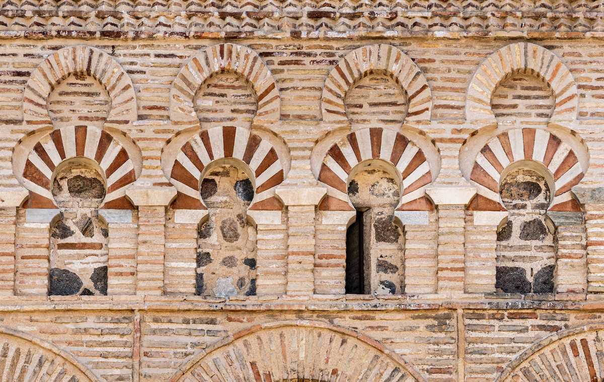 Close up view of small brick arches on the façade of a mosque.