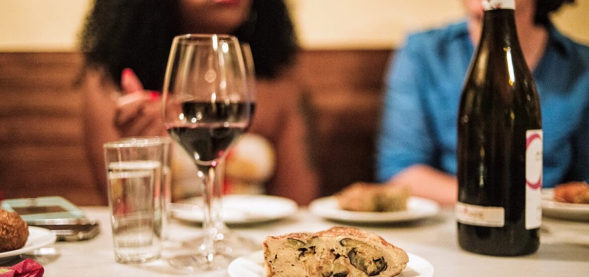 Potato and eggplant omelet on a table next to a glass of red wine