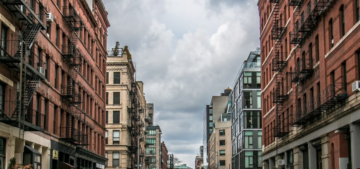 Cobblestone street lined by multi-story brick buildings on an overcast day