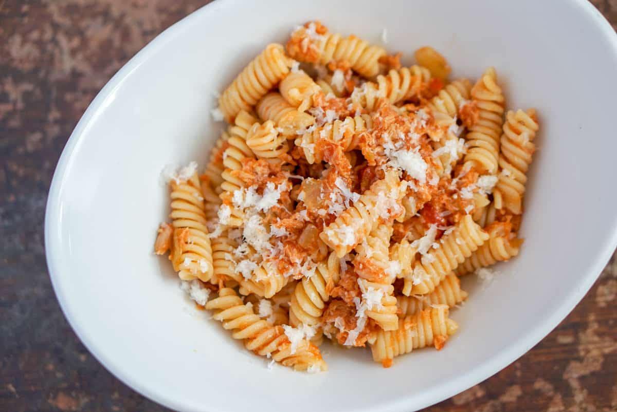 Fusilli pasta with tomato sauce, tuna, and grated cheese.