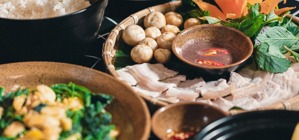 Several plates of Vietnamese food on a black surface